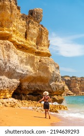 A Woman With A Hat In The Algarve On The Beach At Praia Da Coelha, Albufeira. Portugal