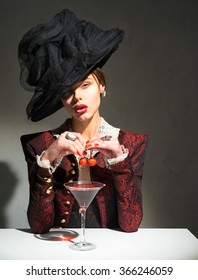 Woman In A Hat Drinking A Martini With A Cherry