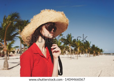  woman in a hat and glasses on a background of palm trees Ocean                             