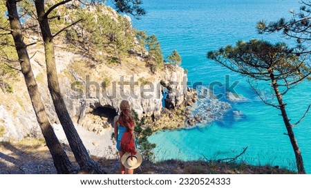 Woman with hat looking at tropical paradise beach- summer travel,  vacation concept- Brittany in France