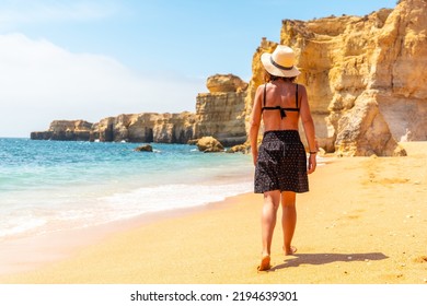 A Woman With A Hat On A Beach Holiday At Praia Da Coelha, Algarve, Albufeira. Portugal