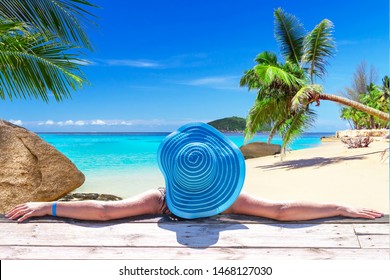 Woman in hat on tropical holidays at the beach