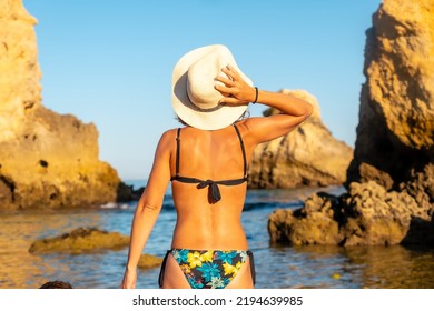 A Woman With A Hat On Vacation At Praia Dos Arrifes, Algarve Beach, Albufeira. Portugal