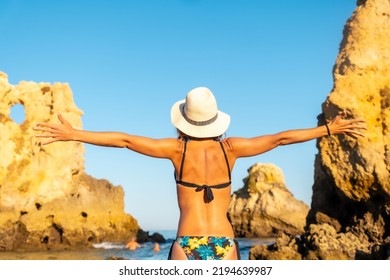 A Woman With A Hat On Vacation At Praia Dos Arrifes, Algarve Beach, Albufeira. Portugal