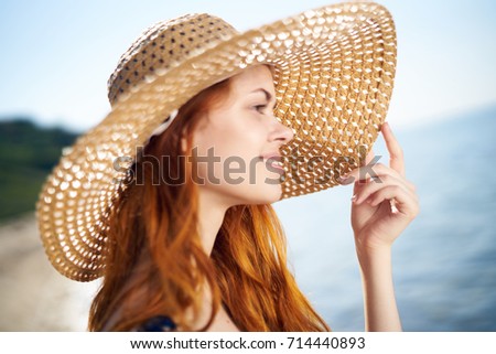 woman in hat in profile on the background of the sea                               