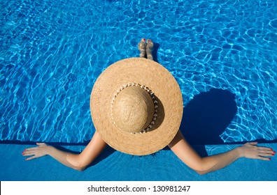 Woman In Hat Relaxing At The Pool