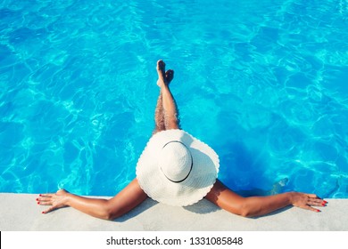 Woman In Hat Relaxing At The Pool 