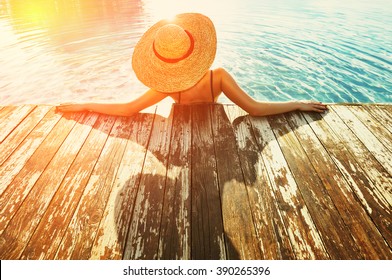 Woman In Hat Relaxing At The Pool 