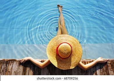 Woman In Hat Relaxing At The Pool