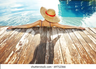 Woman In Hat Relaxing At The Pool