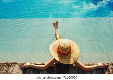 Woman In Hat Relaxing At The Pool