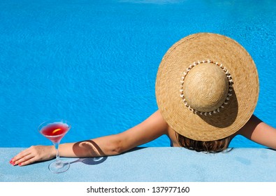 Woman In Hat Relaxing At The Pool With Cosmopolitan Cocktail