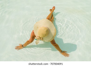 Woman with hat at the swimming pool - Shutterstock ID 707004091