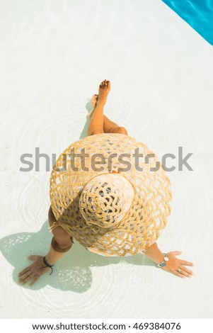 Woman with hat at the swimming pool