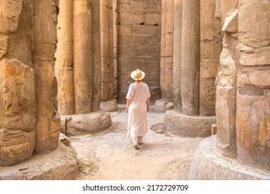 Woman With A Hat Walking Backwards Through The Temple Of Luxor