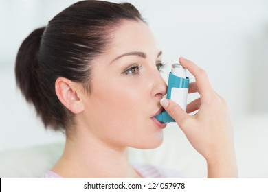 Woman having asthma using the asthma inhaler for being healthy