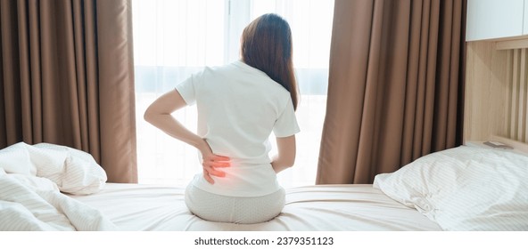 woman having back body ache during sitting on bed at home. adult female with muscle pain after Waking up due to Piriformis Syndrome, Low Back Pain and Spinal Compression. Health medical concept - Shutterstock ID 2379351123
