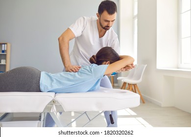 Woman having chiropractic back adjustment. Osteopath, physiotherapist or alternative medicine specialist curing patient's spine problems. Pain relief. Sport injury rehabilitation. Medical massage