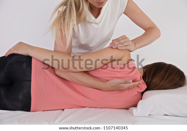 Woman\
having chiropractic back adjustment. Osteopathy, Physiotherapy,\
sport injury rehabilitation concept, holistic\
care