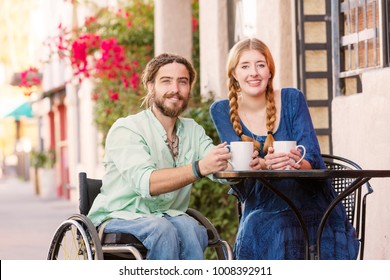 Woman having coffee with male friend in wheelchair at outdoor cafe - Powered by Shutterstock