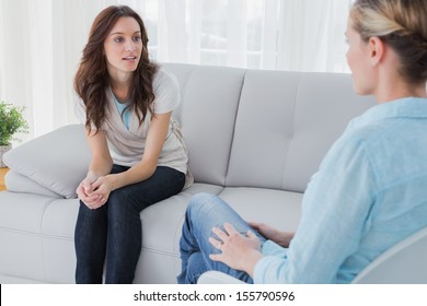 Woman Having A Conversation With Her Therapist On Couch In Office