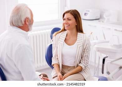 Woman Having Dentist Appointment Sitting At Dental Chair Consulting With Doctor At Dental Clinic