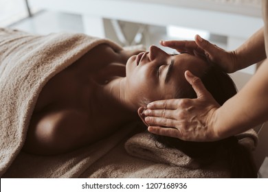 Woman having a facial massage at the spa - Shutterstock ID 1207168936