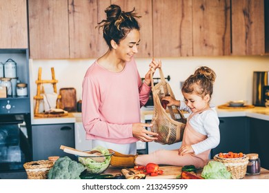 Woman having fun with her daughter while preparing food in the kitchen. - Powered by Shutterstock