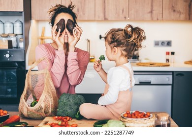 Woman having fun with her daughter while preparing food in the kitchen. - Powered by Shutterstock