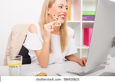 Woman Having Granola Bar While Working 