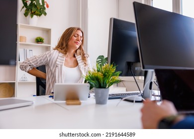 Woman Having Headache And Backpain While Sitting At Her Office Desk, Tired After A Long Day At Work