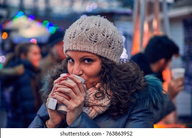 Woman Having Hot Drink Outdoors On Winter Market