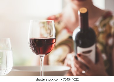 Woman Having Lunch At The Restaurant And Reading A Wine Label On The Bottle, Fine Drinking And Wine Culture Concept