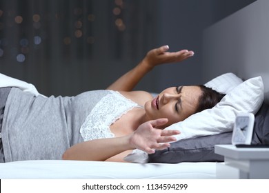 Woman having a nightmare lying on the bed in the night at home - Powered by Shutterstock