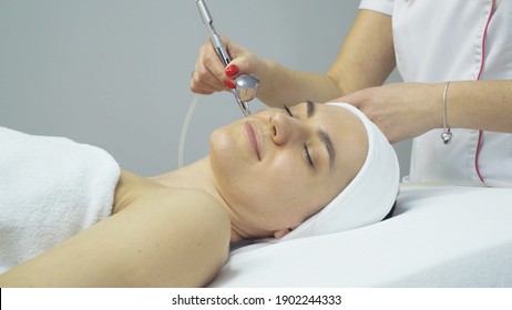 Woman having oxygen facial treatment in beauty salon