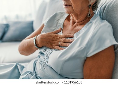 Woman having a pain in the heart area. Heart Attack. Painful Chest. Health Care, Medical Concept. High Resolution. Woman having heart attack at home - Shutterstock ID 1131956183