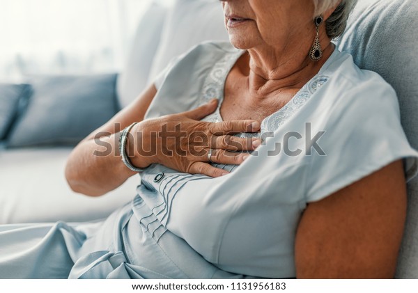 Woman having a pain in the heart area.\
Heart Attack. Painful Chest. Health Care, Medical Concept. High\
Resolution. Woman having heart attack at\
home