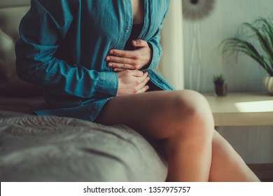 Woman having painful stomach ache. Female suffering from abdominal pain. Pain in the abdomen due to menstruation period and PMS. Inflammation in the body and infection, cystitis