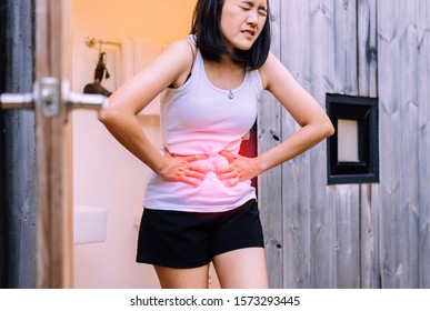 Woman having painful stomachache at home,Female suffering from abdominal pain,Period cramps,Hands squeezing belly