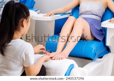 Woman having pedicure procedure in  spa salon