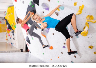 Woman having phone call during climb training in bouldering gym. - Powered by Shutterstock