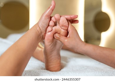 Woman having reflexology foot massage in wellness spa center - Powered by Shutterstock