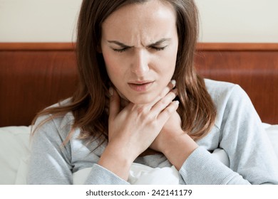 Woman Having A Sore Throat Lying In Bed