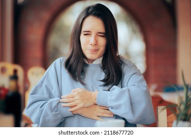 
Woman Having A Stomachache At The Restaurant After Eating. Young Person Having Gastrointestinal Problems After Huge Meal
