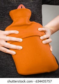 Woman having strong back pain holding hot red water bottle on her spine. Health care, remedy for pains concept