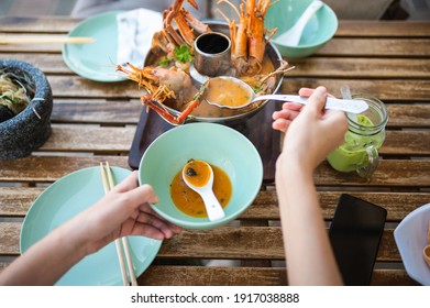 Woman Having Thai Tom Yum Soup With Prawns And Crab In A Restaurant First Person View