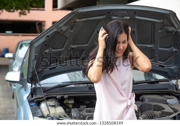 woman having trouble with broken car feeling\
stressed and crazy.\
girl using mobile phone calling for help to\
mechanic for car break down problem.\
desperate and upset waiting\
for insurance service.