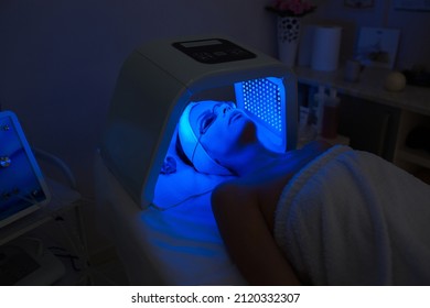 Woman Having Ultraviolet LED Light Facial Treatment At Beauty Salon. Cosmetology. Female Face At Blue Light Treatment At Beauty Clinic.