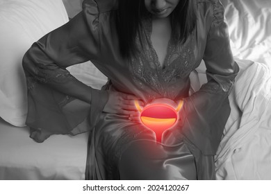 A woman having urethritis and Urinary Incontinence. Female in a satin nightgown with hands holding her crotch at night. Cystitis symptoms with woman