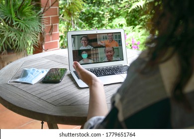 Woman Having Video Call And Chat With Family Via Computer Laptop At Home With Garden View